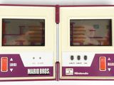 two game consoles sitting side by side on a white surface