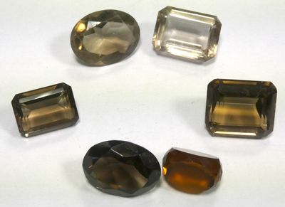 a group of five different colored gems sitting on top of a white surface