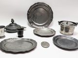 a lot of silver plates and bowls on the table