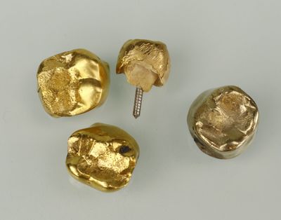 trois pièces d'or sont représentées sur un fond blanc