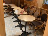 tables and chairs are lined up in a restaurant with brick walls
