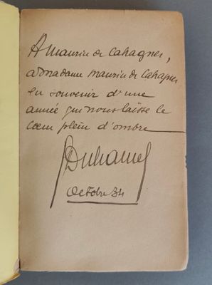 un livre ouvert, sur lequel est posée une note manuscrite, posé sur une table