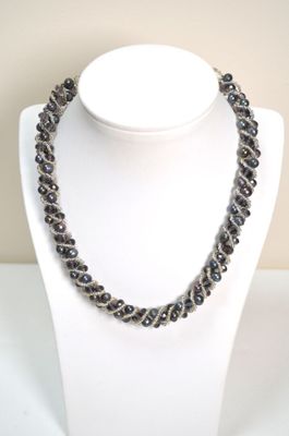 collier composé de perles de verre noires sur un mannequin blanc