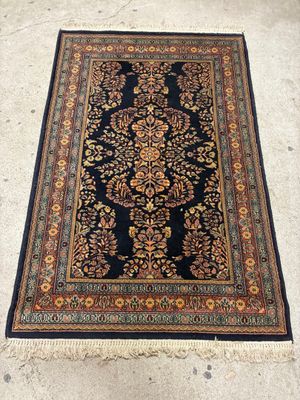 un tapis noir et doré orné d'un motif floral