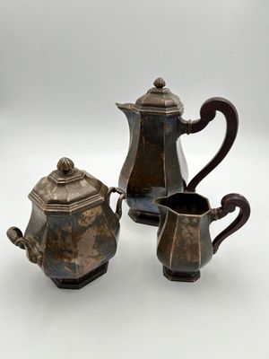 three pieces of antique silverware on a white surface
