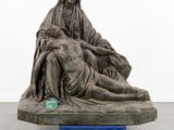 an image of a sculpture of a woman laying on a man ' s lap
