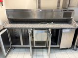 une cuisine équipée d'appareils électroménagers en inox et de plans de travail en granit