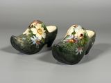 une paire de sabots ornés de fleurs peintes sur un fond gris