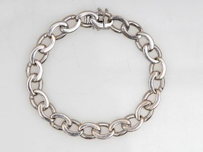 gros plan d'un bracelet en chaîne en argent sur une surface blanche