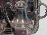a silver tray with a silver tea pot and two cups on it