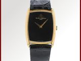 une photo d'une montre-bracelet noire et dorée, dotée d'un bracelet en cuir noir