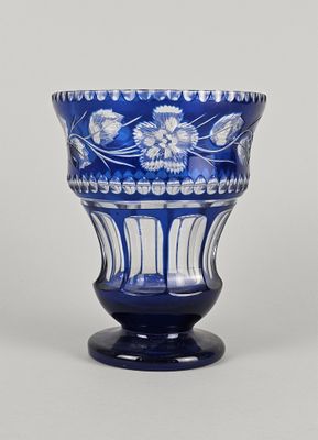 un vase bleu avec des fleurs posé sur une table