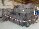 a large pile of crates in a warehouse with a red and white tape