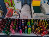 many bottles of soda and other drinks on a shelf