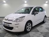 la petite voiture blanche est garée sur un carrelage à carreaux