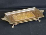 brass plate with ornate design on top of it on a black background