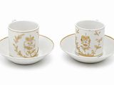 deux tasses et soucoupes ornées de motifs dorés sur fond blanc