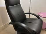 a black leather recliner chair in the corner of a room