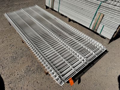 un tas de barres d'acier posé par terre à côté d'une palette