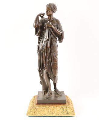an antique bronze statue of a woman holding a bird on a base