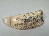 a small piece of ivory that has a boat on it