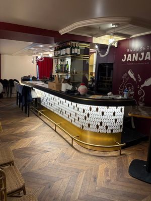 une photo d'un restaurant avec un bar et des chaises