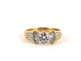 a yellow gold ring with a diamond and baguets