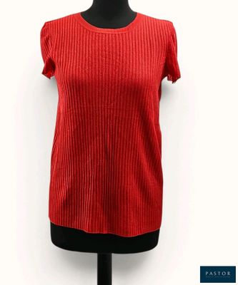 le haut d'un pull rouge pour femme sur un mannequin