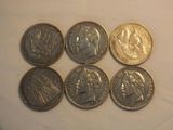 six different types of coins are shown on a white surface