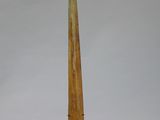 wooden sculpture of a long horn on a stand against a white background