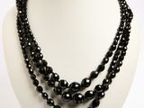 Collier à trois rangs de perles d'onyx noir sur un mannequin