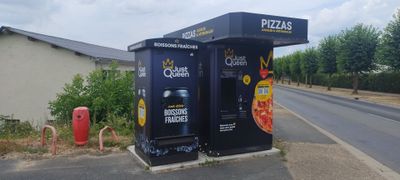 un stand de pizzas au bord de la route, à côté de la route