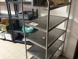 a metal cart with four shelves and a bag on top