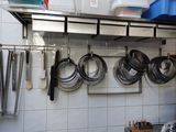 pots and pans are hanging on a wall in a kitchen
