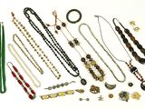 divers colliers et bracelets disposés sur une surface blanche