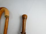 two wooden canes sitting next to each other on a wall