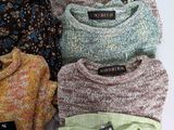 several sweaters are stacked on top of each other on a table