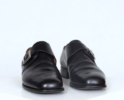 paire de chaussures en cuir noir avec boucles sur fond blanc