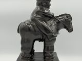 an image of a statue of a man riding a horse wearing a top hat
