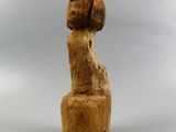 a wooden statue of a woman sitting on top of a wooden block
