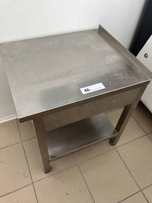 une table en acier inoxydable sur laquelle est posée une pancarte
