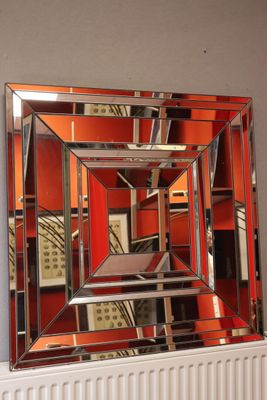 un miroir accroché au mur au-dessus d'un radiateur dans une pièce