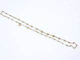 a close up of a gold chain bracelet on a white surface