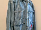 denim jacket on a mannequin stand in front of a white wall