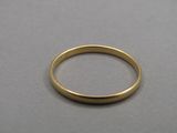 a close up of a gold ring on a gray surface