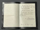 an open book with a handwritten letter on it sitting on top of a table