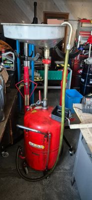 un réservoir d'essence rouge posé à côté d'une borne d'incendie rouge dans un garage