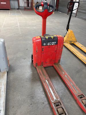 a red forklift sitting in the middle of a warehouse