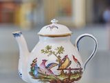 a white tea pot with a bird design on it