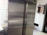 a stainless steel refrigerator in a kitchen with tile flooring